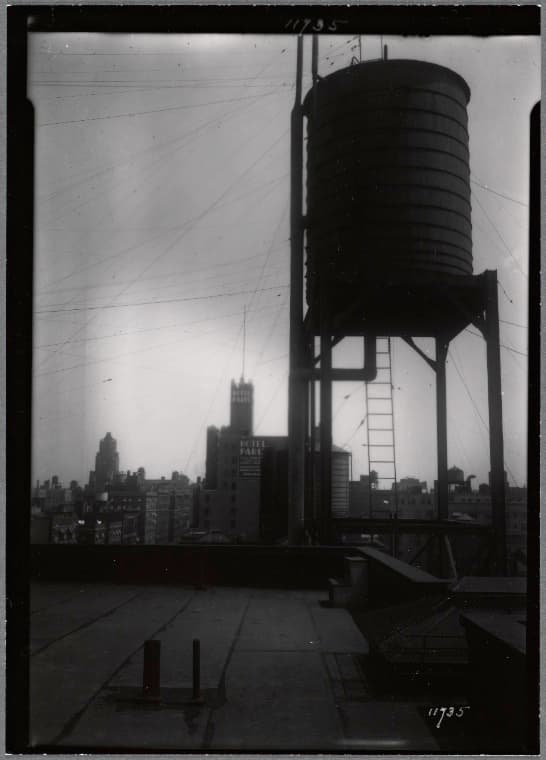 Water tower; view of Hotel Paris (West End Ave & 97th St.) in distance: Manhattan, 1934