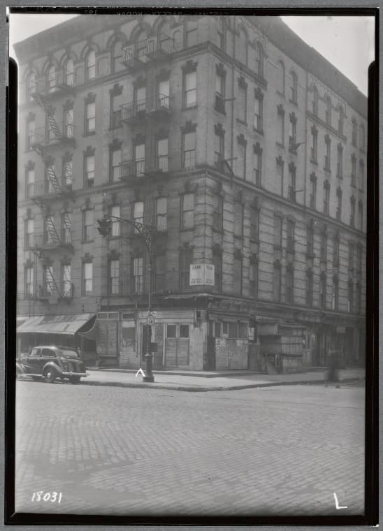 Tenement and storefronts; Rt NY 1A road sign: 1st Ave- E. 104th St., Manhattan, 1937