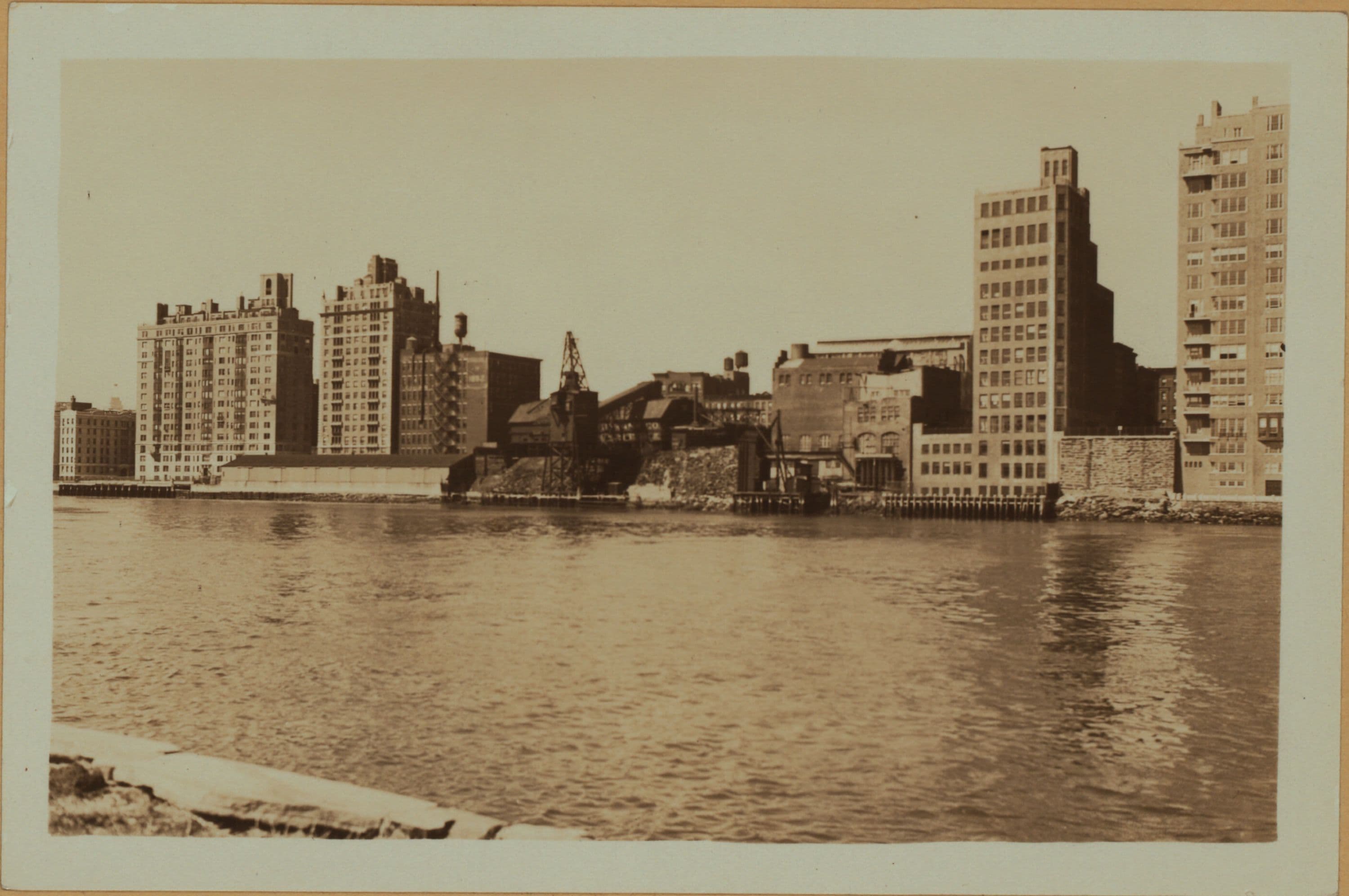 East River - Shore and skyline of Manhattan between East 78th and 89th Streets - Queensborough Bridge - [Brearly School; Yorkgate; Yorkville Ice Sales Corporation.]