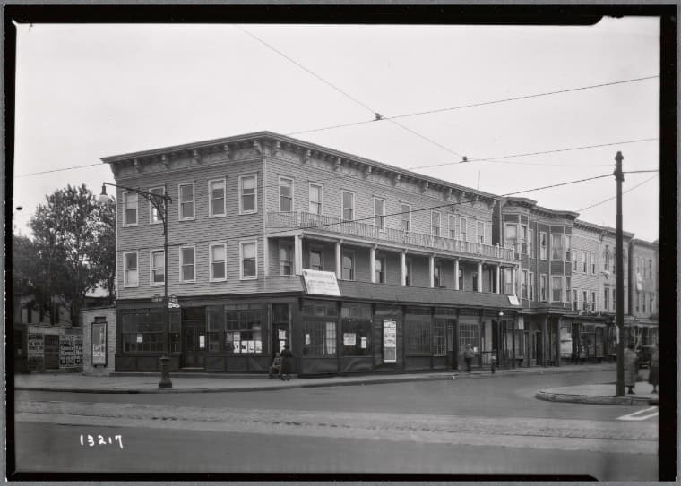 Row of wood frame buildings; Furnished Rooms sign: Surf Av-W. 22nd St., Brooklyn, 1934