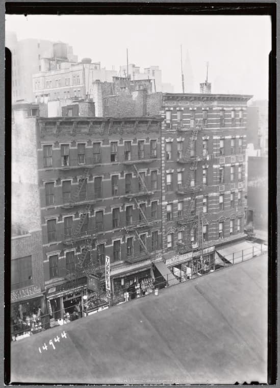 Tenements and storefronts with Christmas lights, from Elevated line: 1st Ave. - E. 12th St., Manhattan, 1935–1936