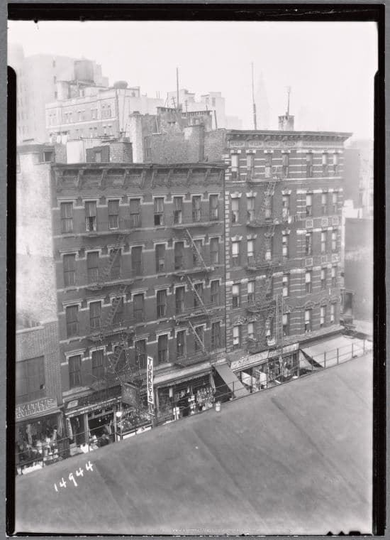 Tenements and storefronts with Christmas lights, from Elevated line: 1st Ave. - E. 12th St., Manhattan